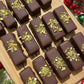 Chocolate bars with pistachio pieces arranged in a grid pattern.